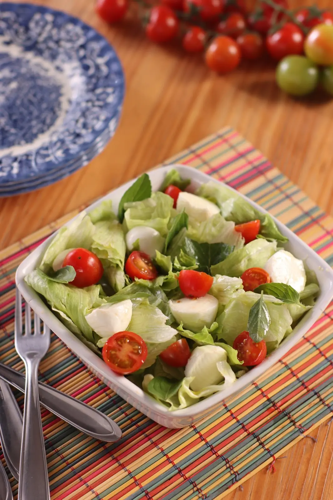 Salada caprese fresh numa travessa branca sobre jogo americano listrado